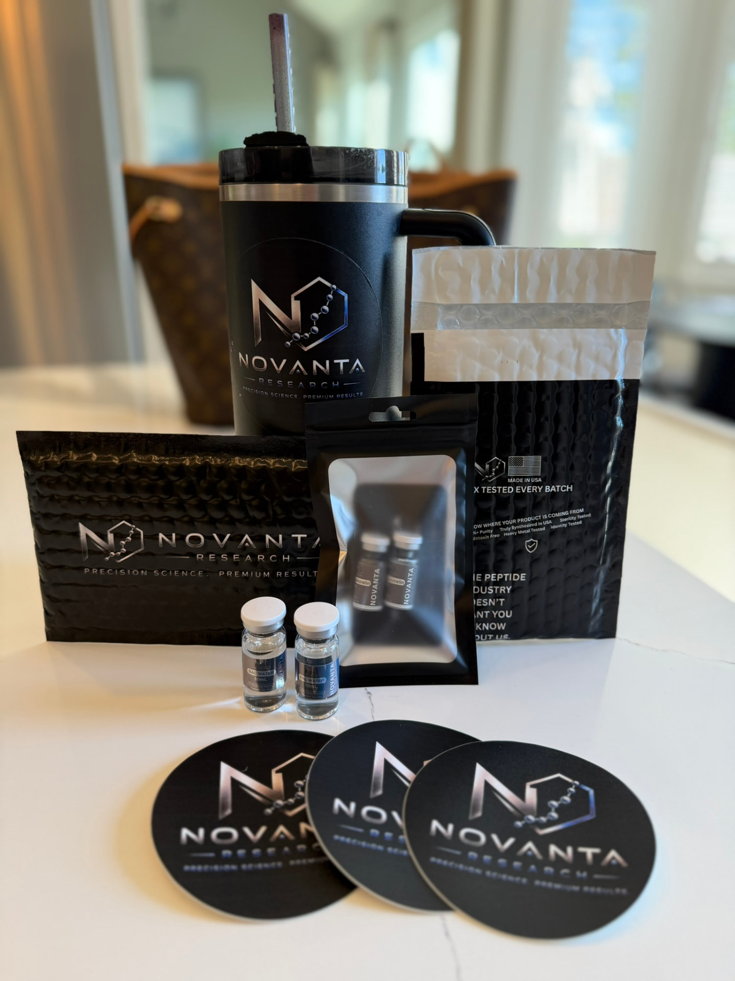 Novanta Research branded tumbler, mailers, peptide pouch and coasters